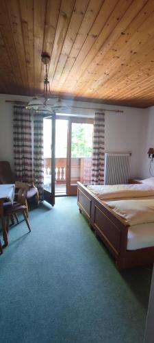 a bedroom with a large bed with a wooden ceiling at Gästehaus Moorbad Gmös in Laakirchen