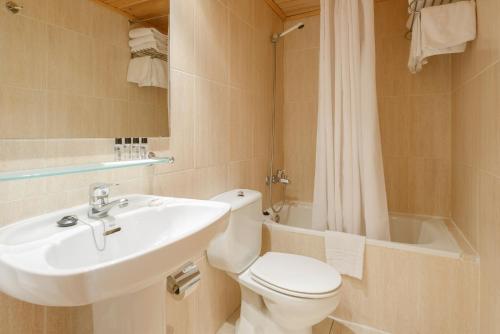 フォルミガルにあるHotel Nievesolのバスルーム(トイレ、洗面台、バスタブ付)