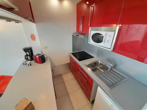 a small kitchen with a sink and a microwave at Village Naturiste - Port Ambonne in Cap d'Agde