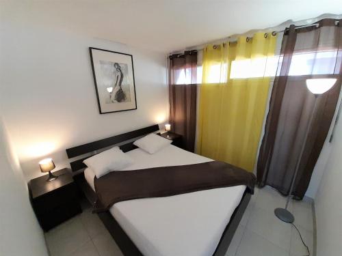 une petite chambre avec un lit et une fenêtre dans l'établissement Village Naturiste - Mords moi, au Cap d'Agde