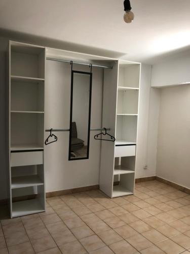 um quarto com prateleiras brancas e um espelho em Logement au cœur du village de Rasteau em Rasteau