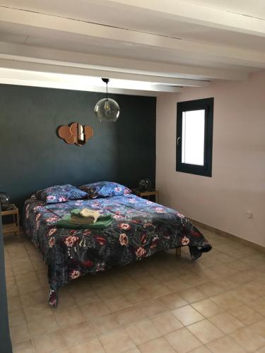 um quarto com uma cama com um cobertor colorido em Logement au cœur du village de Rasteau em Rasteau