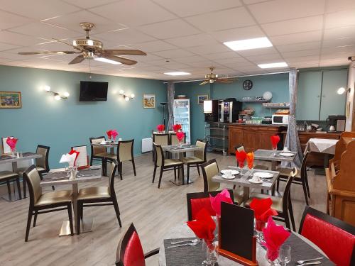un restaurant avec des tables et des chaises avec des arches rouges dans l'établissement Hotel De La Paix, à Albert