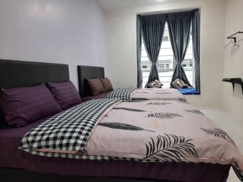 a bedroom with a bed with a comforter and a window at BC Homestay @ Emerald Avenue Apartment, Brinchang in Brinchang