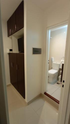 a bathroom with a toilet and a door to a room at Hotel Dinastia Boutique in Salta