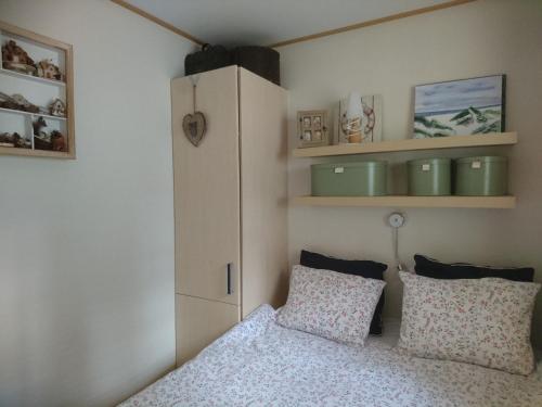 een slaapkamer met een bed, een kast en kussens bij Rapunzel in Laag-Soeren