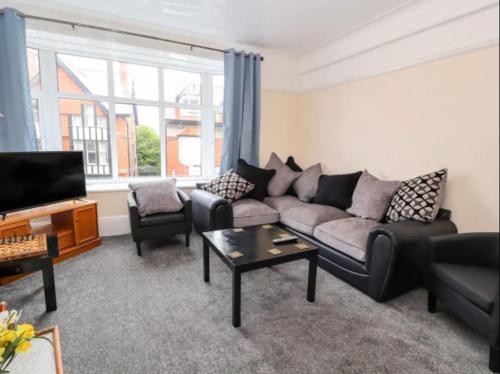 a living room with a couch and a table at Seabreeze Apartment in Llandrillo-yn-Rhôs