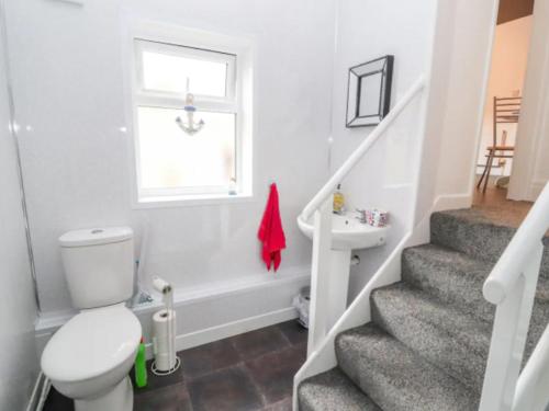 La salle de bains est pourvue de toilettes et d'un lavabo. dans l'établissement Seabreeze Apartment, à Llandrillo-yn-Rhôs