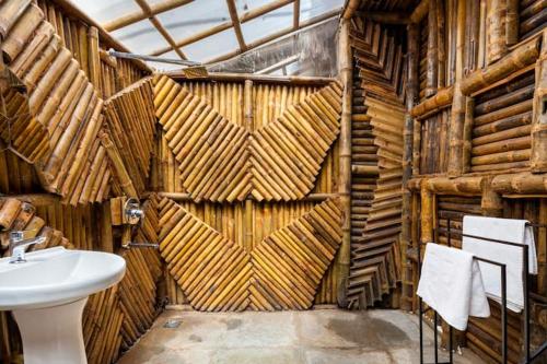 a bathroom with a sink and a wooden wall at Vagatorian - Stylish Luxury Designer Cottages in Vagator