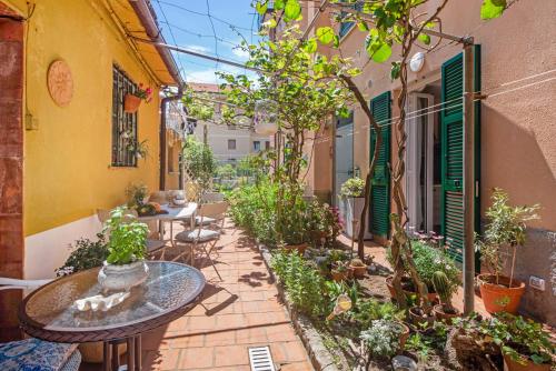 Un patio al aire libre con mesas y plantas en macetas. en Un'oasi al Mare, en Moneglia