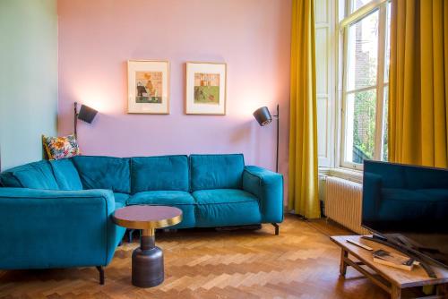 a living room with a blue couch and a table at B&B Het Hart van Haarlem in Haarlem