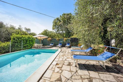 a swimming pool with lounge chairs next to a yard at Casa Paola e del Poeta in Costa Carnara