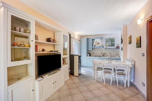 a kitchen with a table and a television and a dining room at Casa Paola e del Poeta in Costa Carnara