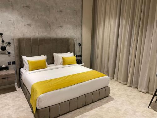 1 dormitorio con 1 cama grande con almohadas amarillas en Voyage Residence en Riad