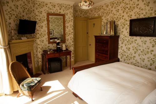 a bedroom with a bed and a fireplace and a television at St Katharine's House in Milford Haven
