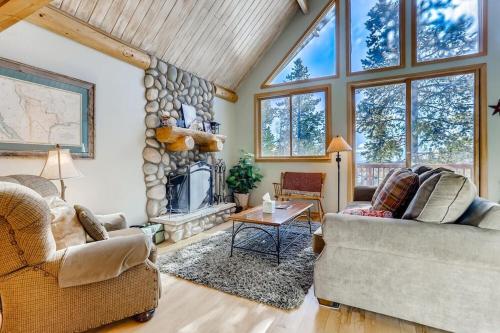 a living room with two couches and a stone fireplace at Lovely House Tucked in the Pines with Private Hot Tub - Pura Vida in Alma