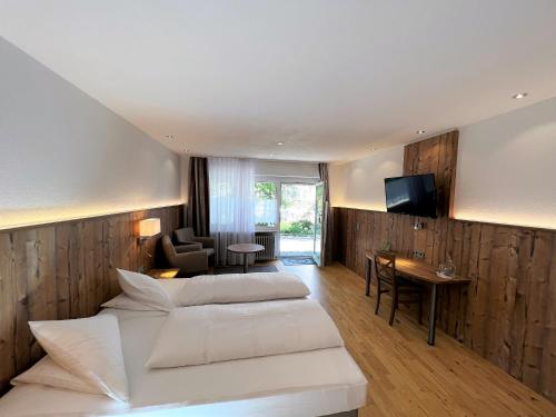 レーッフィンゲンにあるWildkräuter-Gasthof Lindeのベッド2台とデスクが備わるホテルルームです。