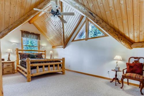a bedroom with a bed and a ceiling fan at Lovely House Tucked in the Pines with Private Hot Tub - Pura Vida in Alma