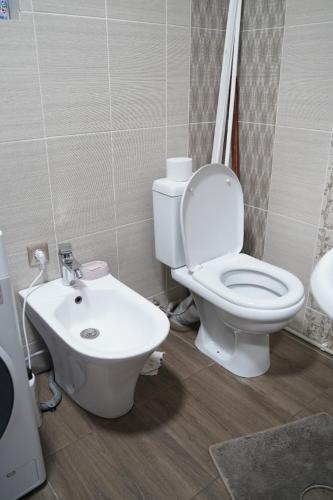 a bathroom with a toilet and a sink at KF_Guest House-Madina in Shabdan