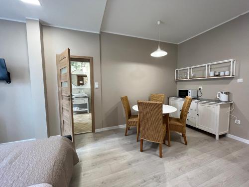 a bedroom with a table and chairs and a kitchen at Apartamenty Dobranocka in Krotoszyn