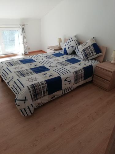 a bedroom with a bed with a comforter and pillows at Florennes Gîte neuf 150 M2 devant un grand lac privé de 2 hectares poissonneux au milieu des bois in Florennes
