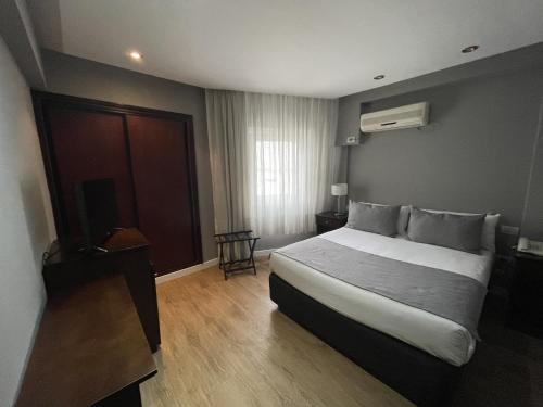 a hotel room with a bed and a television at Hotel 8 de Octubre in Buenos Aires