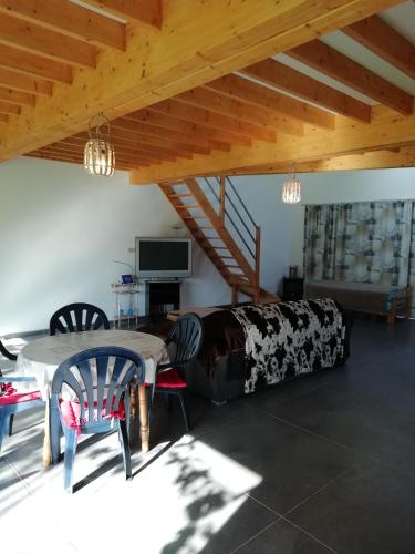 a living room with a table and chairs and a couch at Florennes Gîte neuf 150 M2 devant un grand lac privé de 2 hectares poissonneux au milieu des bois in Florennes