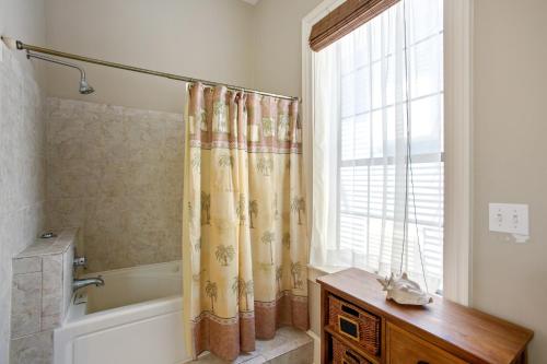 a bathroom with a tub and a shower curtain at Antigua Key - just a couple blocks to Seawall Beaches, shops, restaurants and Pleasure Pier! home in Galveston