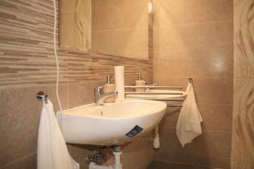 y baño con lavabo, espejo y toallas. en Fekete Gólya Pihenőház, en Baja
