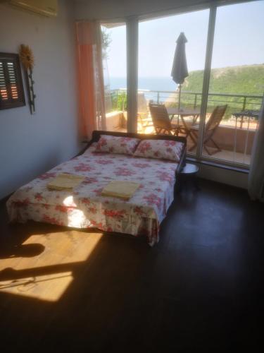 a bedroom with a bed with a view of the ocean at Complex Karia II in Kavarna