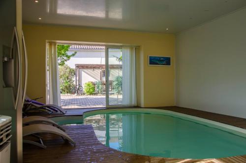- une piscine dans une chambre avec fenêtre dans l'établissement La Pause Céleste, à Ordonnac