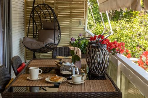 einen Tisch und Stühle auf einem Balkon mit Kaffeetassen in der Unterkunft MS APARTMENT in Athen