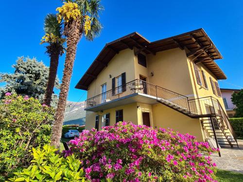 una casa con una palma e fiori di Appartamenti Casa La Rosa a Bellagio