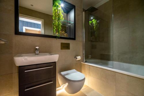 a bathroom with a toilet and a sink and a shower at Waterside Retreat @ Ryedale House in York