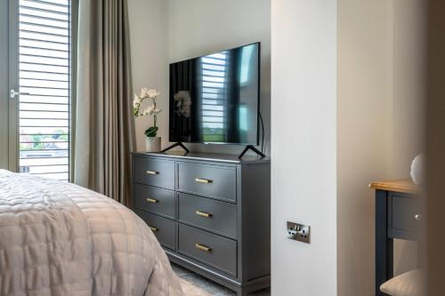 a bedroom with a dresser with a television on it at Waterside Retreat @ Ryedale House in York