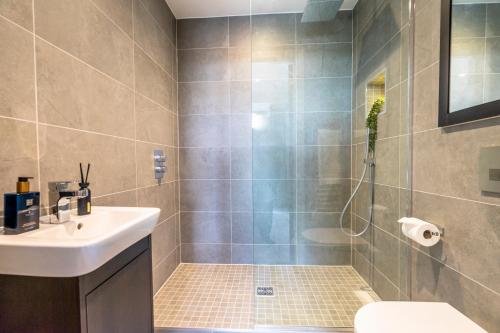 a bathroom with a shower with a sink and a toilet at Waterside Retreat @ Ryedale House in York