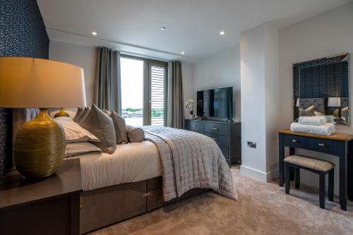 a bedroom with a bed and a desk and a television at Waterside Retreat @ Ryedale House in York
