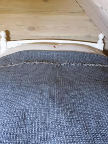 a bed with a bed frame with a blue checked mattress at Amatų kalnelis in Anykščiai