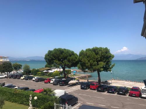 a parking lot with cars parked next to the ocean at Casa Caterina Lake View Holidays in Peschiera del Garda