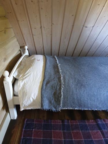 a bed in a room with a wooden ceiling at Amatų kalnelis in Anykščiai
