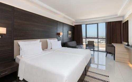 a bedroom with a large white bed and a desk at Radisson Hotel Sfax in Sfax