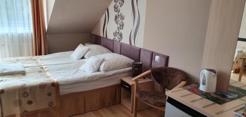 1 dormitorio pequeño con 1 cama y 1 silla en Villa Rekin, en Grzybowo