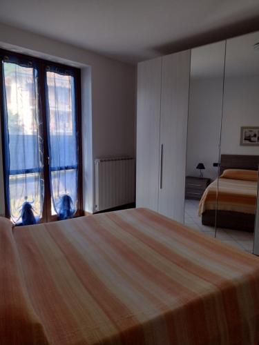 a bedroom with a bed and a large window at Casa Tiziana in Sovere