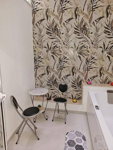 two chairs and a table in a kitchen with a wallpaper at Casa Ciuzza in Siracusa