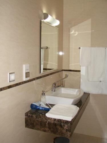 a bathroom with a sink and a mirror and towels at Hotel Apartamentos Baia Brava in Gaula