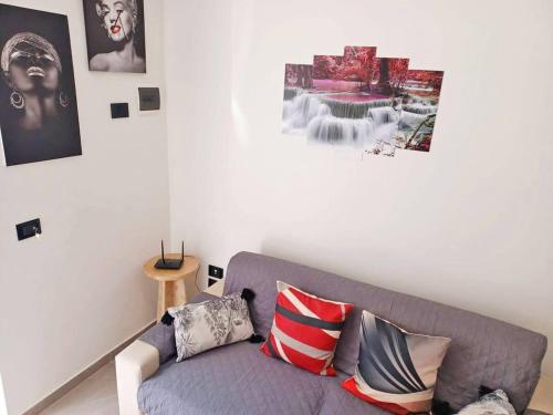 a living room with a gray couch with pillows at Casa Ciuzza in Siracusa