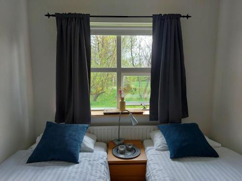 2 camas en una habitación con ventana en The Organist House in Golden Circle, en Skálholt
