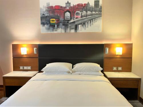 a bedroom with a large bed with a painting on the wall at Hyatt Centric Janakpuri New Delhi in New Delhi