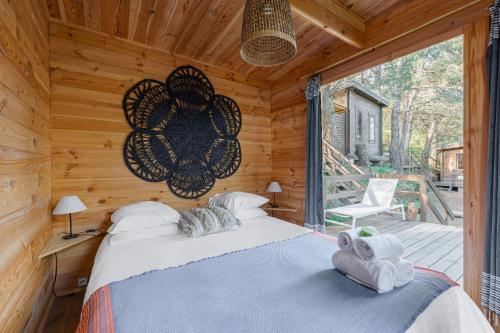 a bedroom with a bed in a log cabin at Les Cabanons de l'Ouille in Collioure