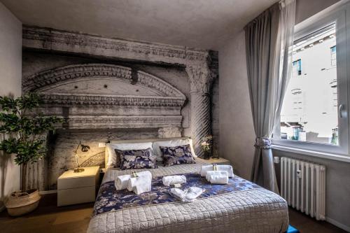 a bedroom with a large bed with a stone wall at Verona Romana Apartments in Verona